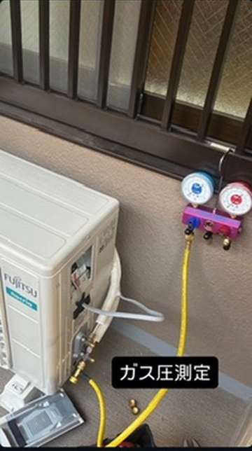 室外機にゲージをつないでガス圧を測定している様子