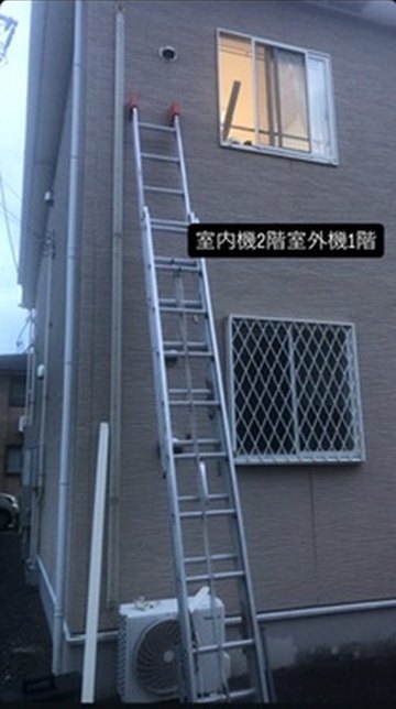 2階の室内機から1階の室外機まで配管をおろし、はしごを立てた外壁