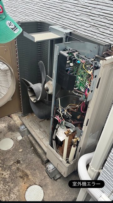 カバーを外して基板と配線を点検している業務用の室外機